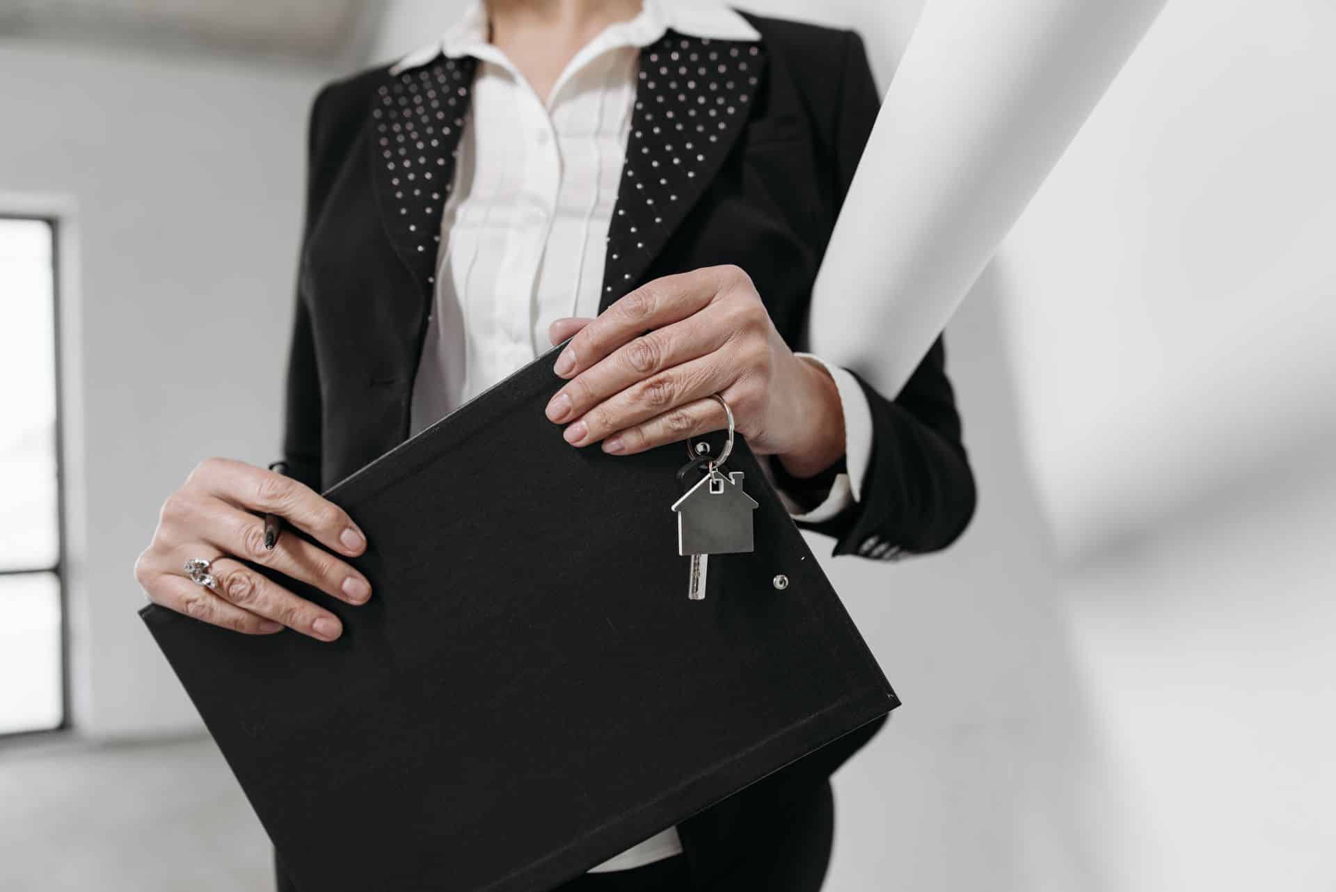a person holding a folder and house keys